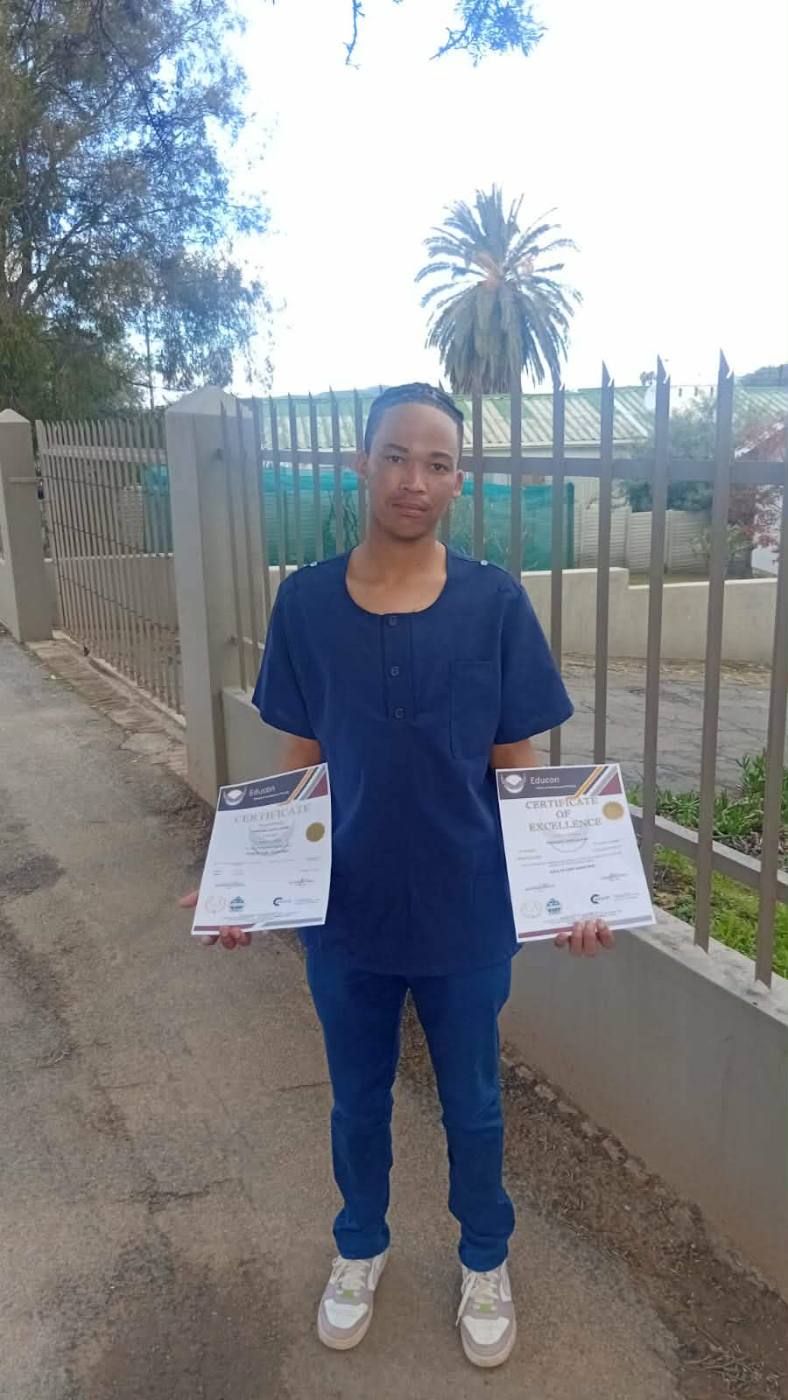 Graduate holding certificates outdoors