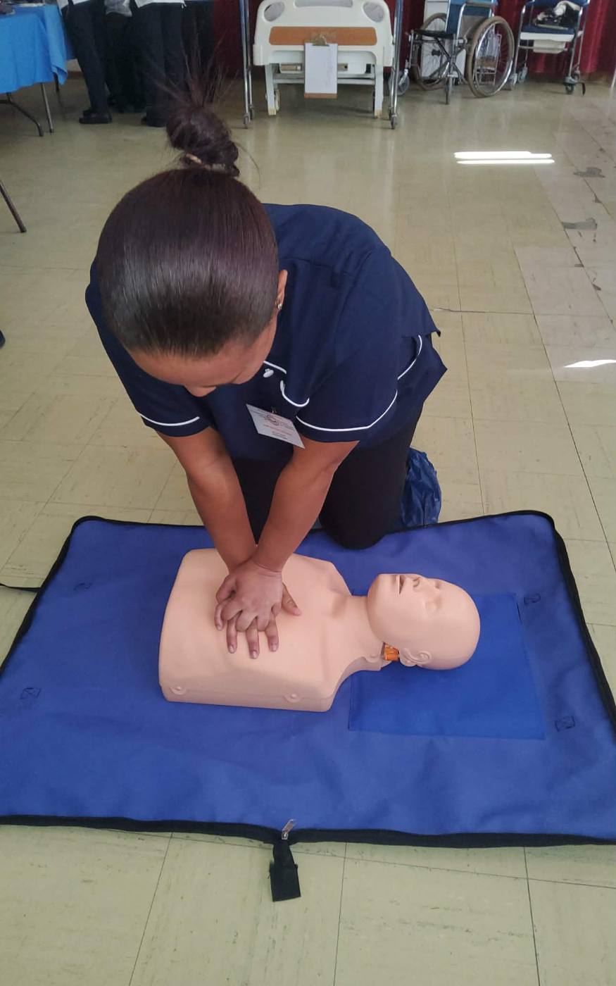 Student practising CPR chest compressions on a manikin