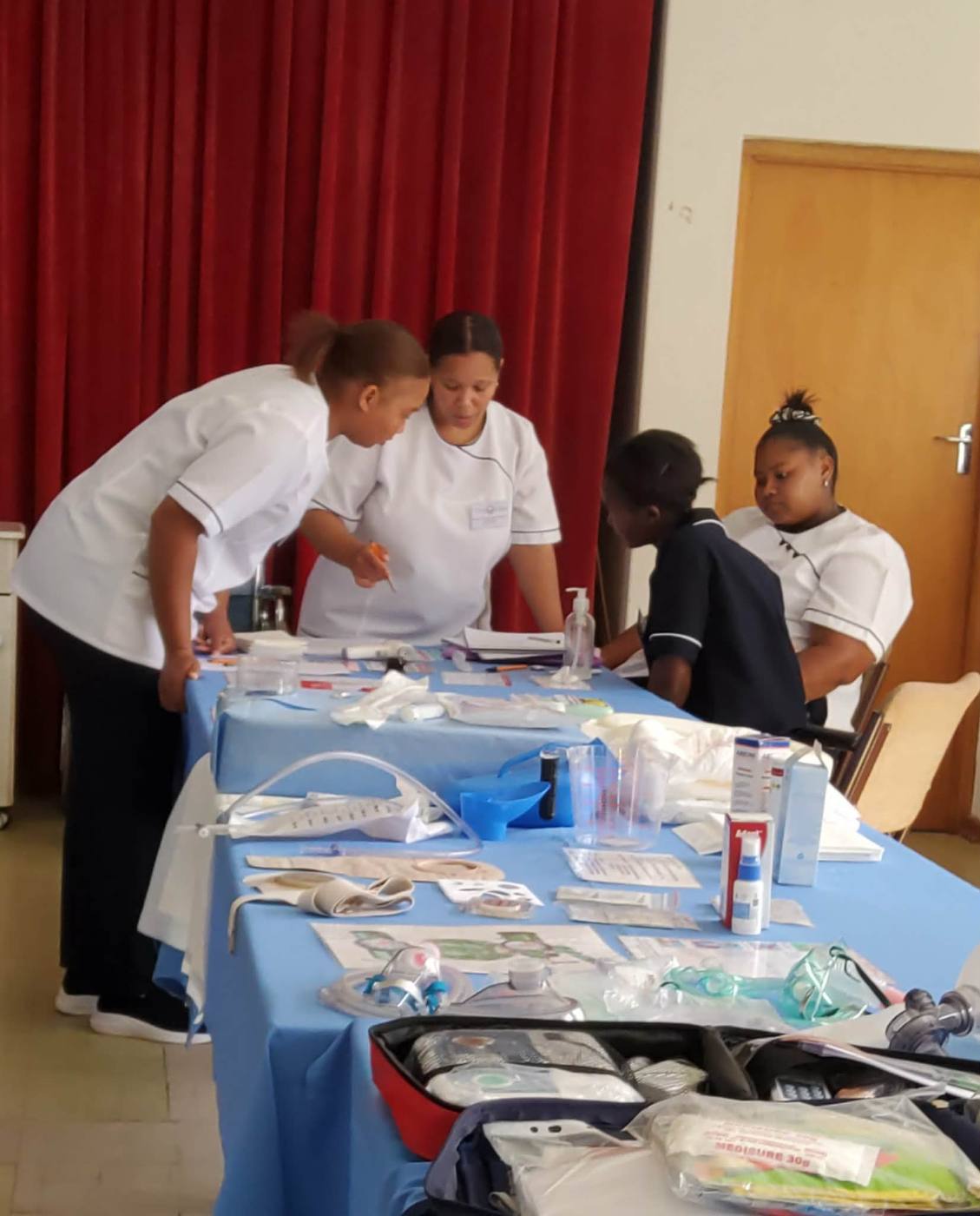 Students practising first aid procedures at a supplies table