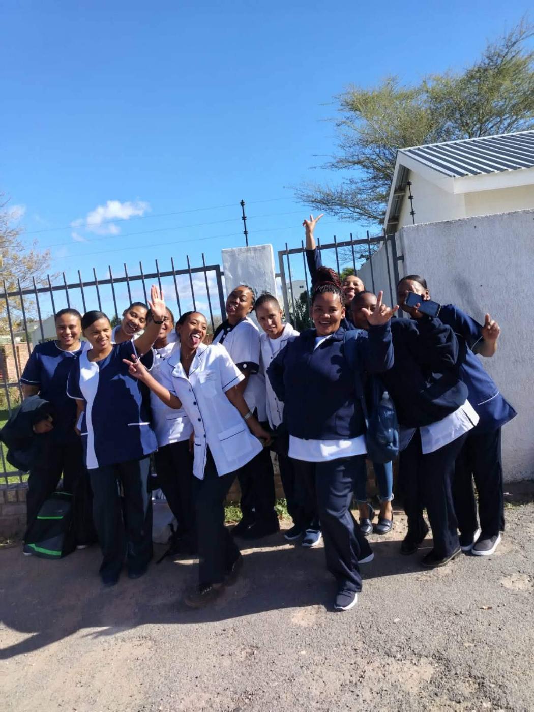 Graduates celebrating with certificates outdoors