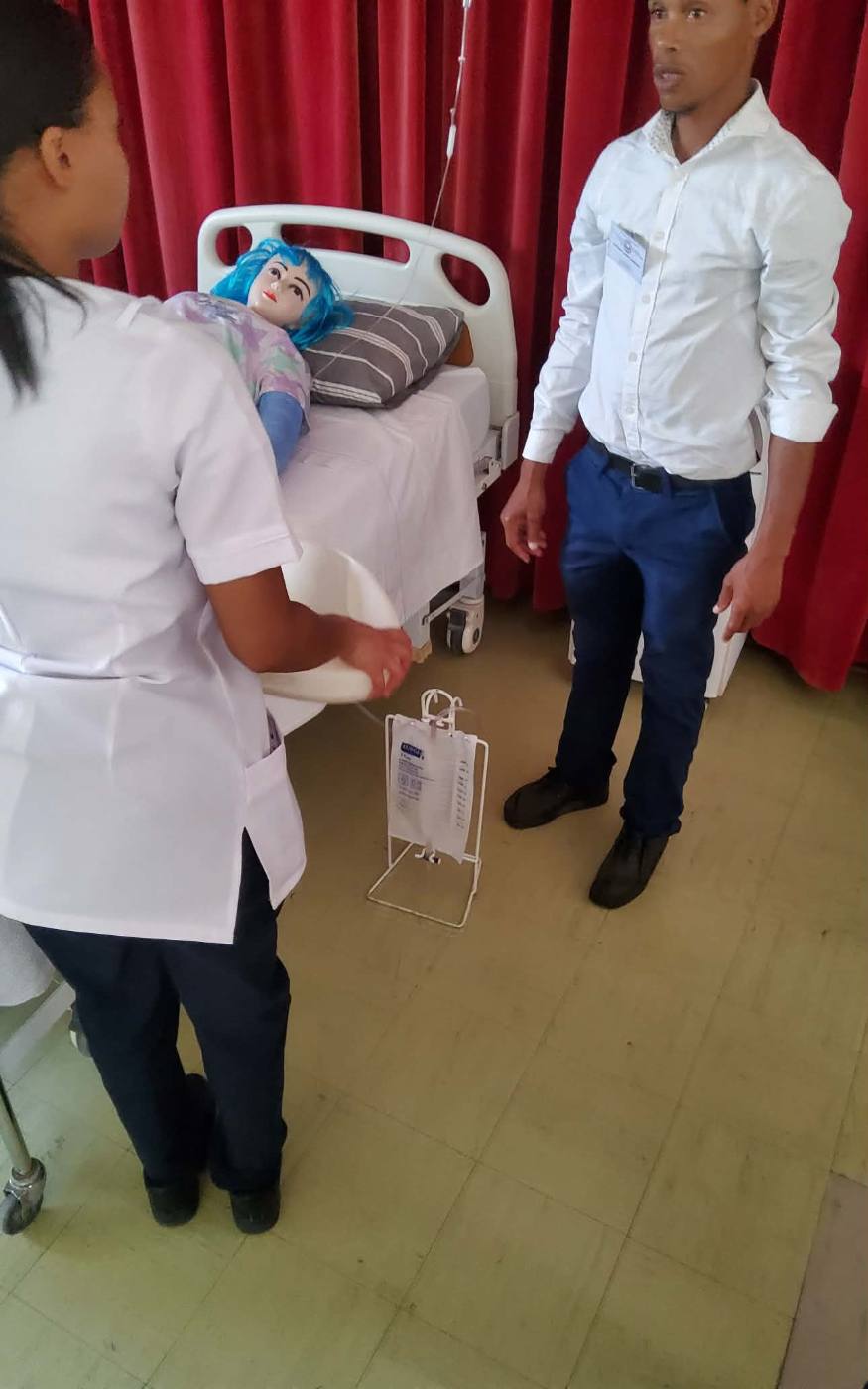 Students practising patient care at a hospital bed
