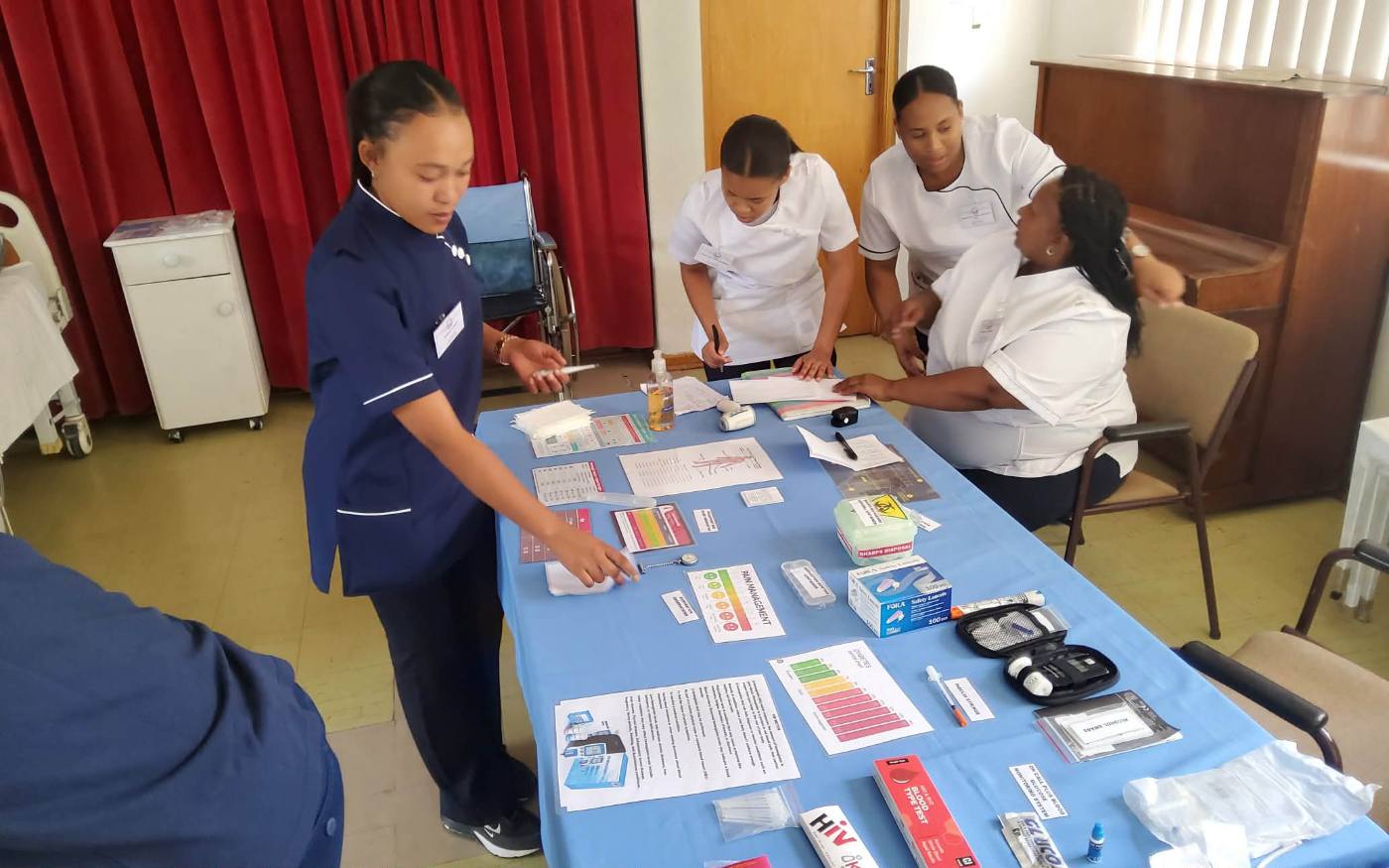 Students reviewing vital signs table at a practical station